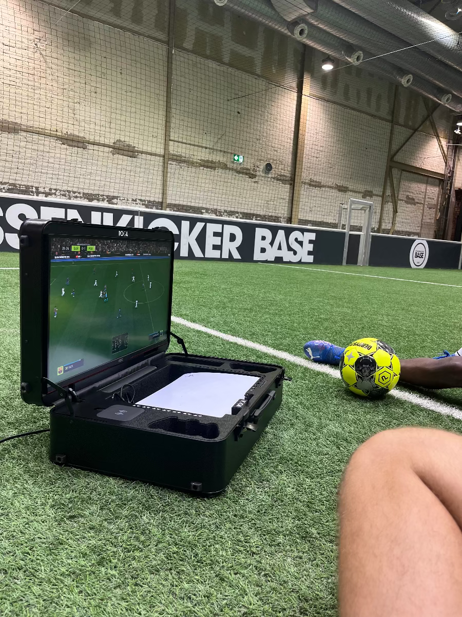 gaming case with a soccer ball nearby on an indoor sports field